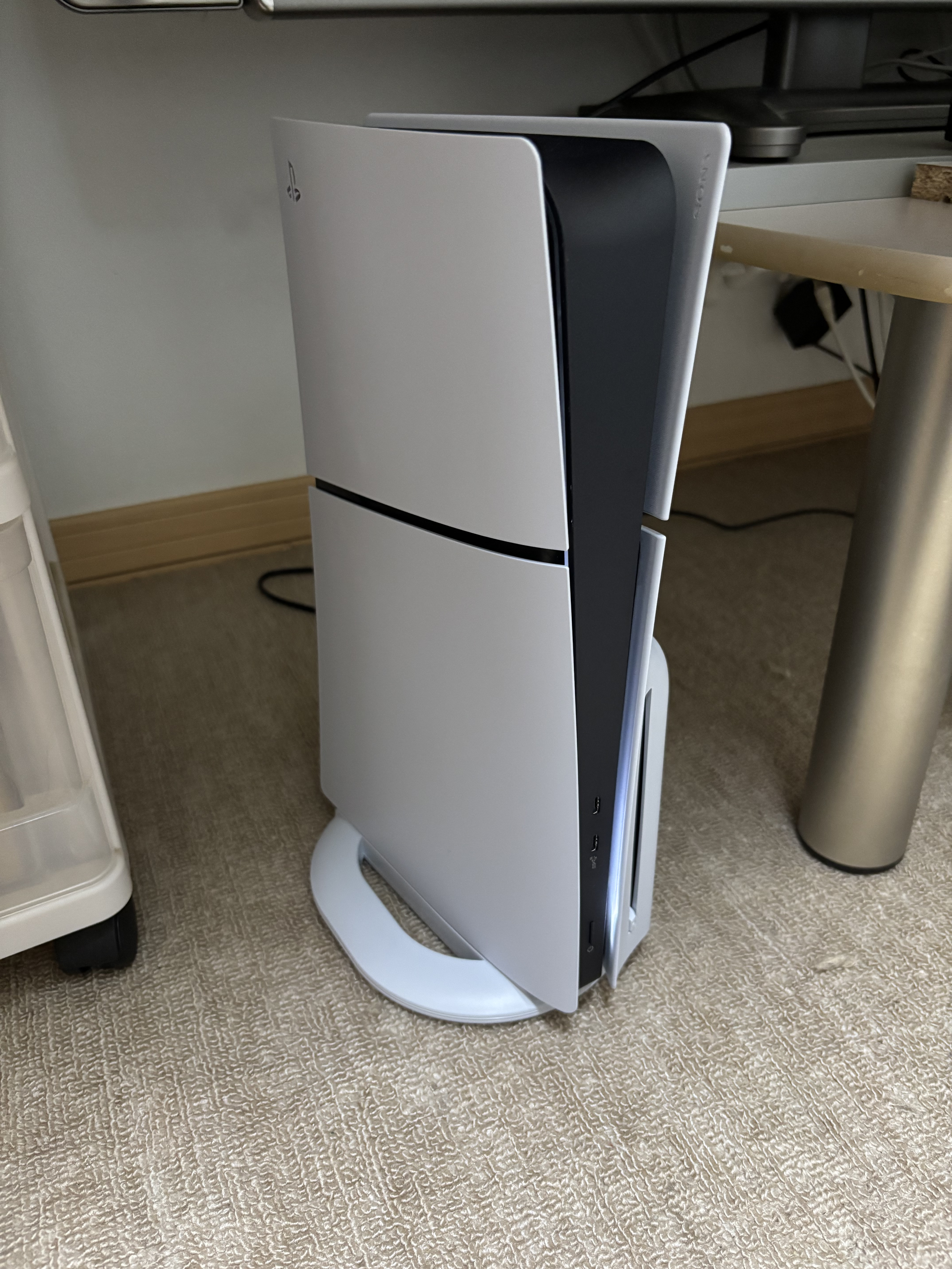 White PS5 Slim Disc console with a separate vertical stand; family photograph, stand not included